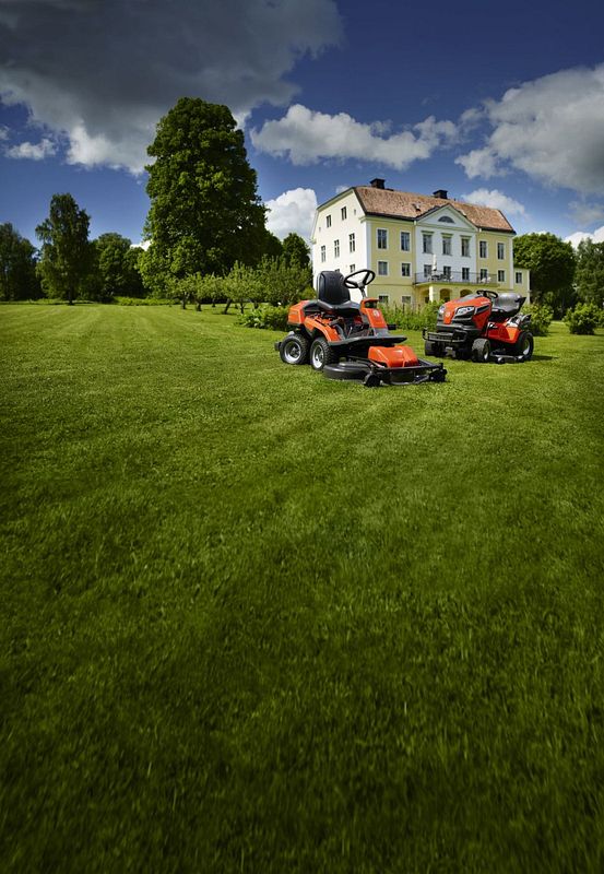 Husqvarna Gartentraktor und Rider auf großer Rasenfläche vor einer Villa